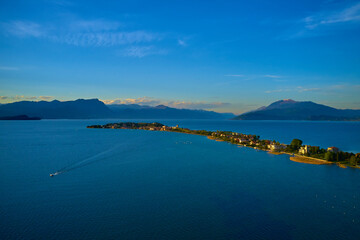 Aerial panorama of Sirmione. Sirmione on Lake Garda drone view. Panorama of Lake Garda. Sirmione, Lake Garda, Italy. Drone view of Sirmione peninsula at sunset. Sirmione Lake Garda Italy aerial view.