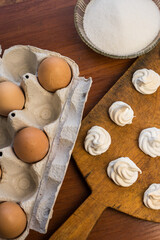 Delicious crispy homemade egg meringue, prepared with love on a wooden background, crunchy dessert for coffee or tea.