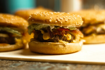
four burgers on a white board, photos indoors