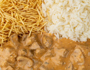 Closeup of meat strogonoff with rice and straw potato