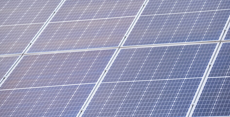 Closeup of building roof with rows of blue solar photovoltaic panels for producing clean ecological electric energy. Renewable electricity with zero emission concept
