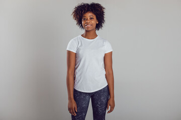 African american woman with puffy hair in a white t-shirt on a white background. Mock-up.