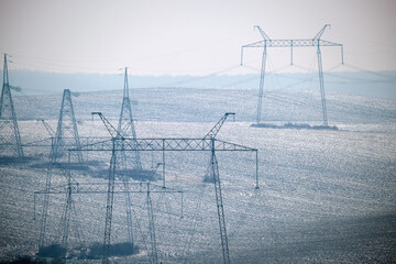 High voltage tower with electric power lines transfening electrical energy through cable wires