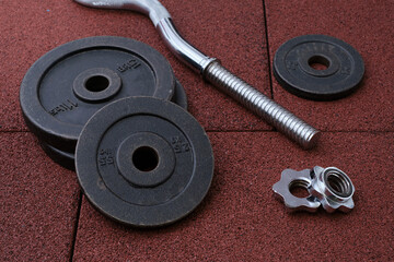 barbell and iron plates on the rubber floor in the gym. black and white photography. Bodybuilding equipment. Fitness or bodybuilding concept background.