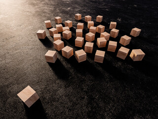 3D rendering of wooden cubes lying on the black, rough surface with one cube isolated from the group