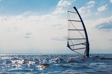 Man on a water sailing windsurfing board.