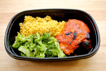 A Meal of a Chicken Thigh with Catalina Dressing Baked on Top, Yellow Rice and Steamed Broccoli