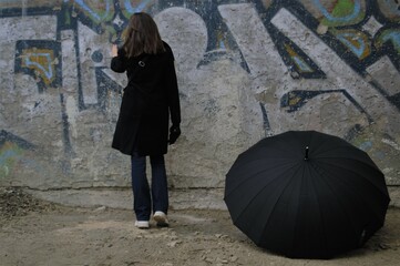 lady with umbrella against the wall