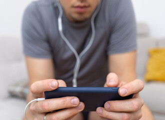young man in headphones watching at mobile phone