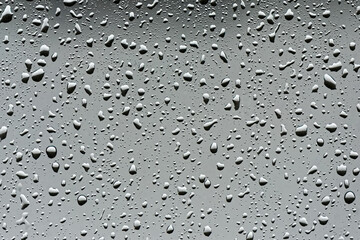 Raindrops on a window pane randomly create shapes with light being refracted