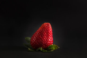 deep red strawberry on black background