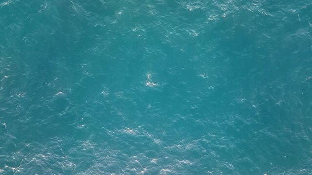 Top view of calm water surface. Aerial view of the sea waters. Ocean surface without waves in the daylight. Water outdoors concept. Water texture.