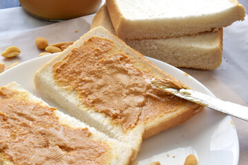 Peanut butter sandwich on a white plate. 