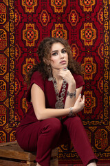 Fashion beautiful girl in old carpet shop. Turkey. Oriental carpet