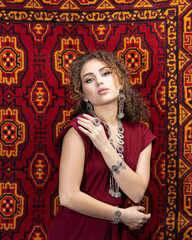 Young beautiful girl in old carpet shop. Oriental carpet and silver jewerelly