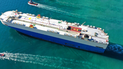Aerial drone photo of large car carrier ro ro vessel guided by tug boats to anchor to Mediterranean...