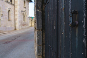 Old knocker in the shape of a hand in an old gate in the town of Llanes, Asturias, Spain 