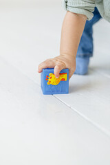 One-year-old baby plays with cubes in the apartment white background