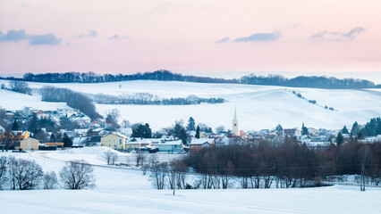 Fototapeta na wymiar Village in snowy landscape in Burgenland