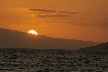 Magical golden sunset from Maui beach, sea and mountain background. 
