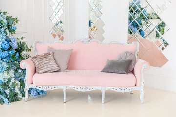 Beautiful luxury classic clean interior living room in white color with pink sofa flower composition. Bright modern stylish interior living room with furniture in classic minimalist style.