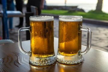 Two pint glasses with cold beer served outdoor