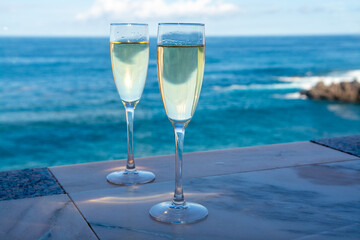 New year celebration with two glasses of champagne or Spanish cava sparkling wine and view on blue Atlantic ocean, Canary islands, winter tourists destination