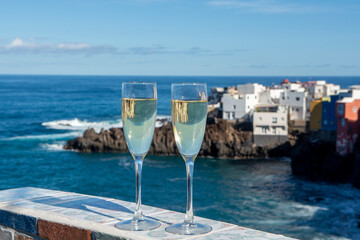 New year celebration with two glasses of champagne or Spanish cava sparkling wine and view on blue Atlantic ocean, Canary islands, winter tourists destination