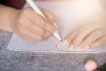 female hands make a pattern on a white felt. Step-by-step instructions for creating hand-made...