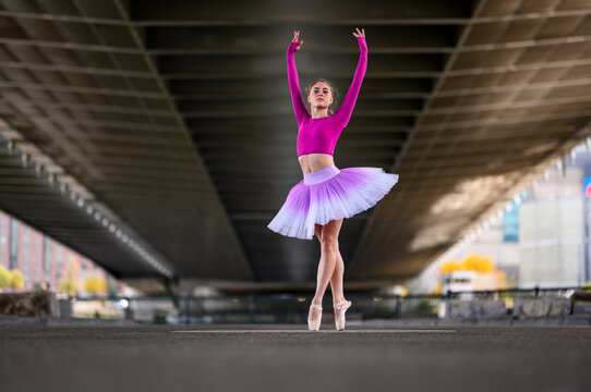 Urban Ballerina dancing in the city under bridge