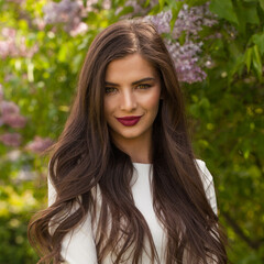 Fototapeta premium Nice smiling woman brunette on floral spring background