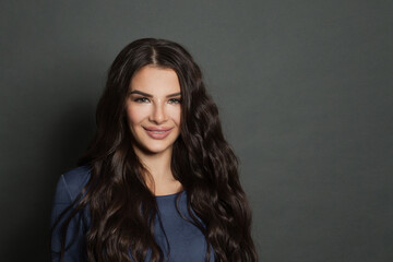 Obraz premium Beauty portrait of cute woman brunette smiling on dark gray background