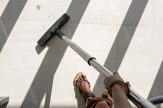 African housekeeper tidying dirty floor