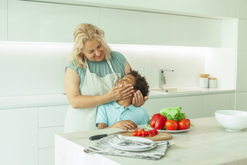 Playful mother and son baking in kitchen