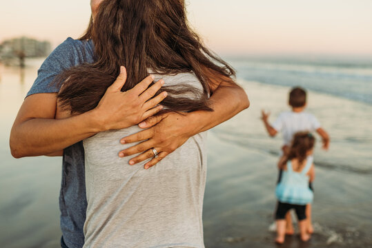 Same-sex couple embraces at beach