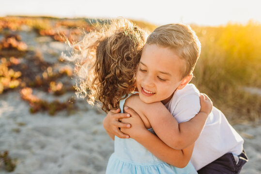 Young siblings hugging at the beach