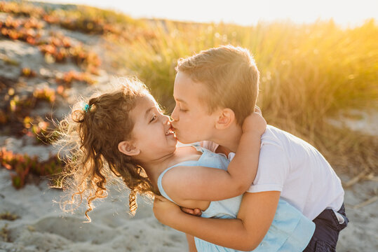 Young brother kissing sister at beach
