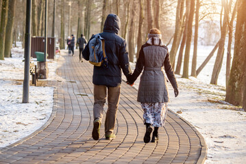  A guy and a girl walking in winter Park
