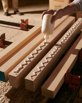 Woodworker Craftsman gluing together a table. 