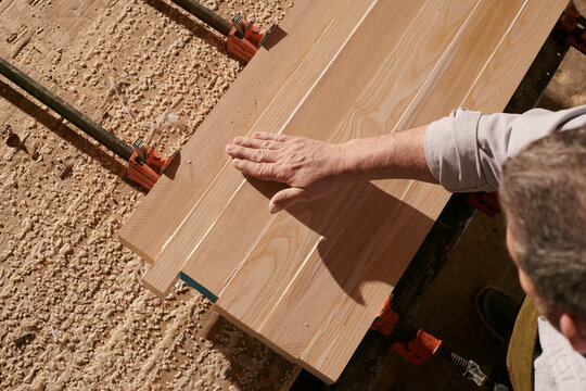 Woodworker Craftsman gluing together a table. 