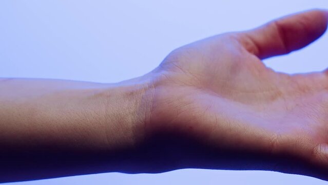 Hand skin in blue neon light, making x-ray of human body part, arm surface macro shooting.