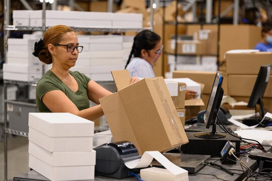 Employees working together shipping cardboard boxes 
