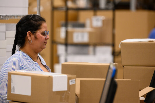 Employee working at desk shipping boxes at warehouse