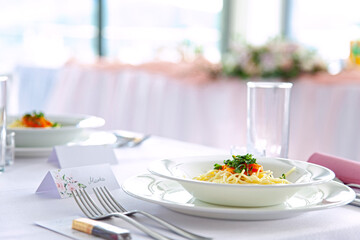 table setting for wedding at elegant restaurant . plates and cutlery prepared. very bright interior