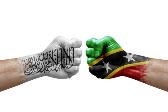 Two hands punch to each others on white background. Country flags painted fists, conflict crisis concept between afghanistan and saint kitts and nevis