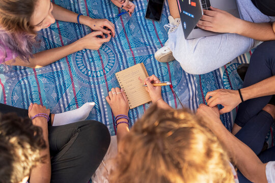 Teens planning trip relaxing on a blanket