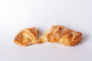 broken walnut croissant on white background