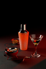 shaker and Martini with cigar, matches, ashtray and bowl of olives, party kit on black background with space for text