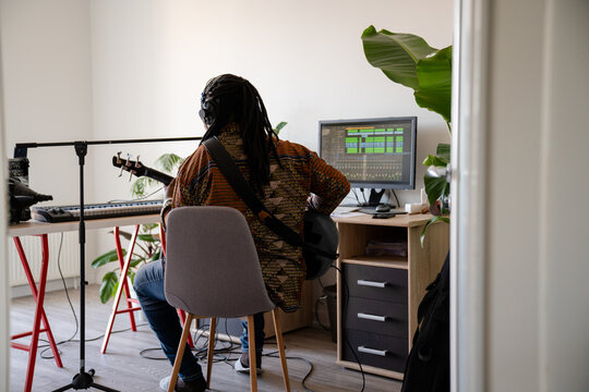 Back View Of Musician Playing Guitar At Home