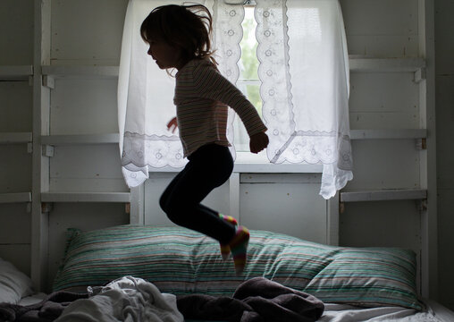 Happy Child Jumping on the Bed at Home